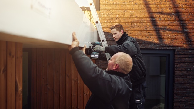 Twee mannen monteren een kunststof boeideel.